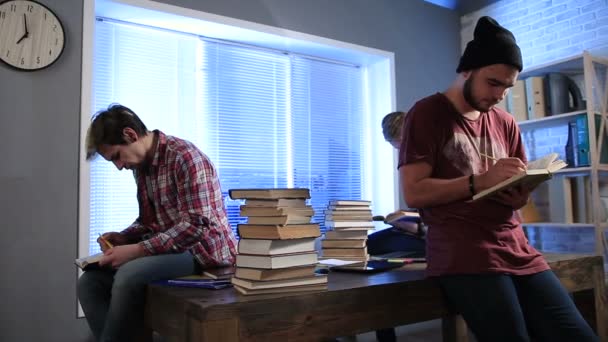 Estudiantes varones investigando con libros en la biblioteca
 - Metraje, vídeo