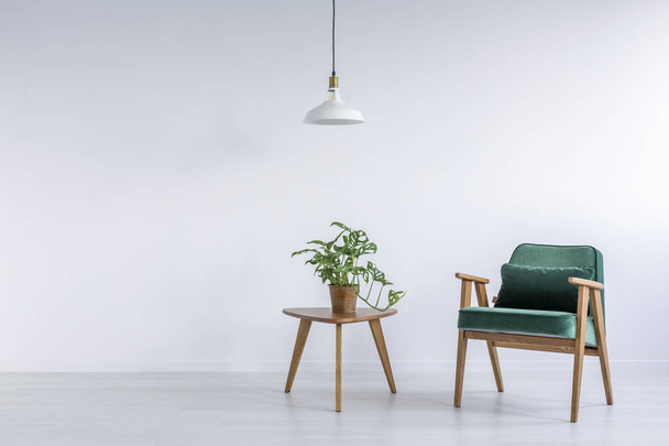 Habitación blanca con sillón verde
 - Foto, Imagen