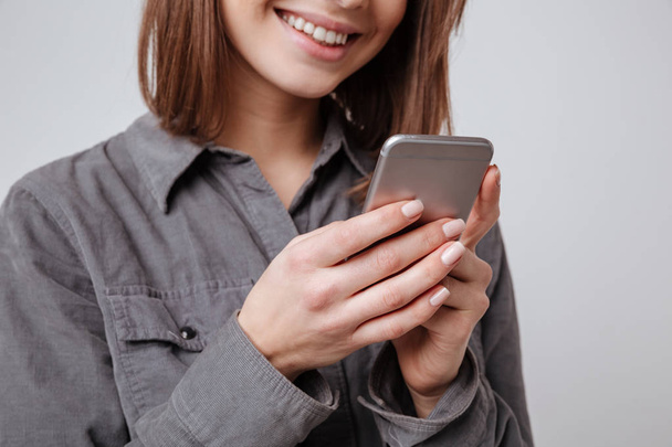 Cropped image of happy young woman using mobile phone. - Photo, Image