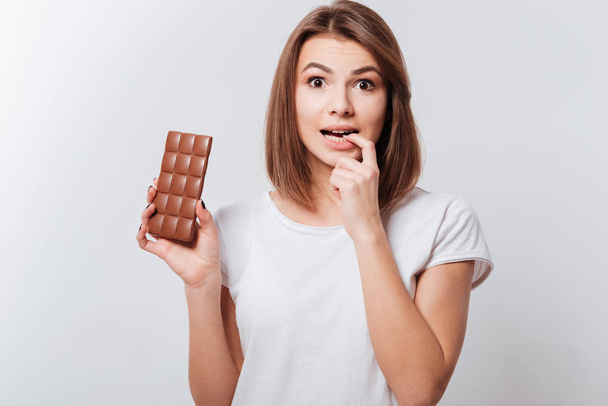 Pretty young woman holding chocolate in hands - Photo, Image
