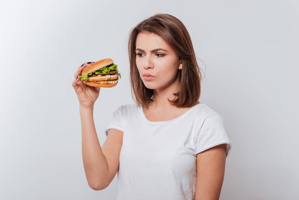 Confused hungry woman eating fastfood - Photo, Image