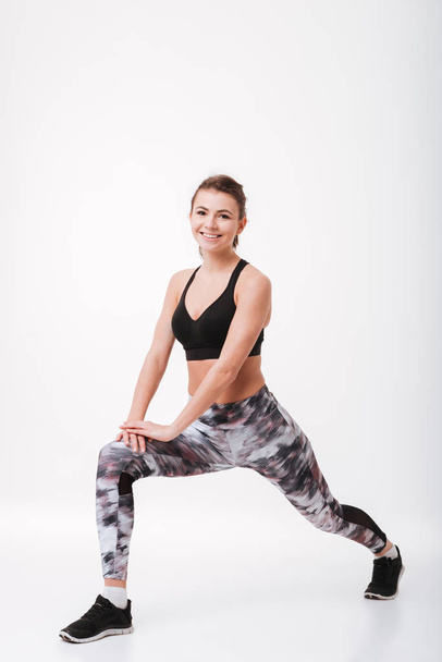 Smiling young fitness woman make sport exercises - Foto, Imagem