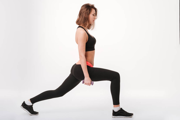 Serious young fitness lady make exercises with dumbbells - Valokuva, kuva