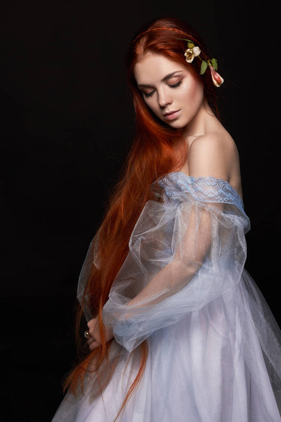 Sexy beautiful redhead girl with long hair in dress cotton retro. Woman portrait on black background. Deep eyes. Natural beauty, clean skin, facial care and hair. Strong and thick hair. Flower - Foto, Bild