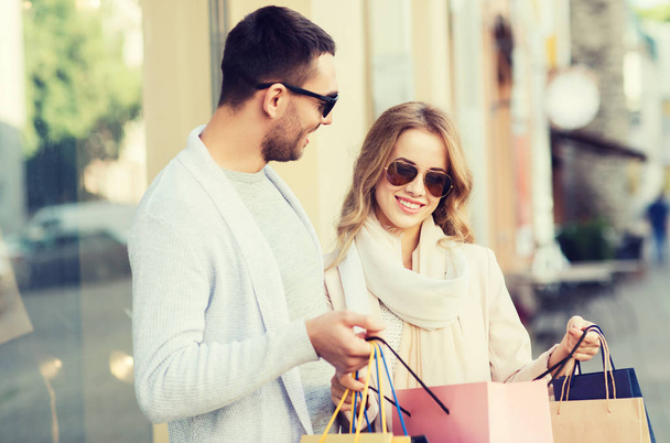 happy couple with shopping bags on city street - Φωτογραφία, εικόνα