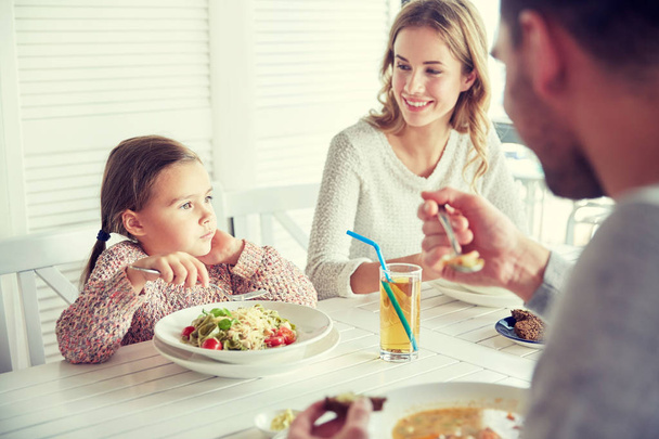 onnellinen perhe syömässä ravintolassa tai kahvilassa
 - Valokuva, kuva