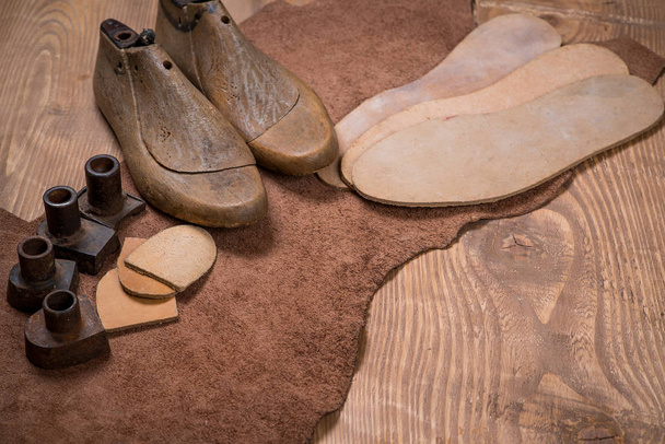 Set lederen craft tools op houten achtergrond. Werkplaats voor schoenmaker. - Foto, afbeelding