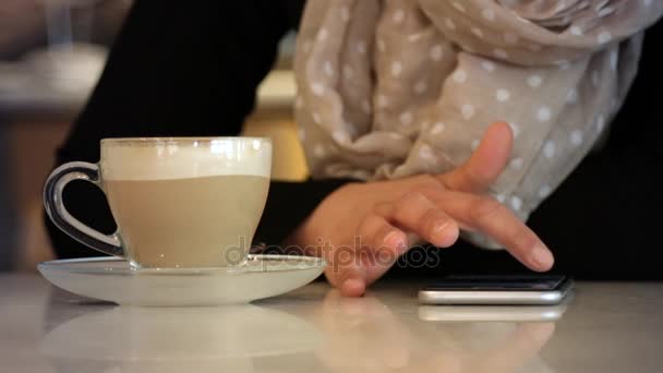 Using smartphone on coffeshop table in slow motion - Filmati, video