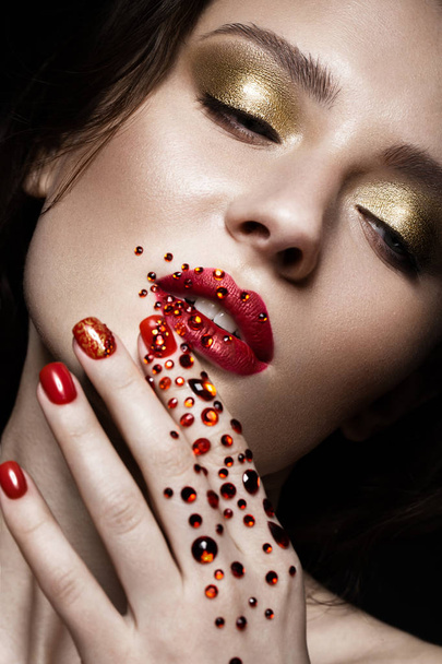Beautiful girl with evening make-up, red lips in rhinestones and design manicure nails. beauty face. - Foto, Bild