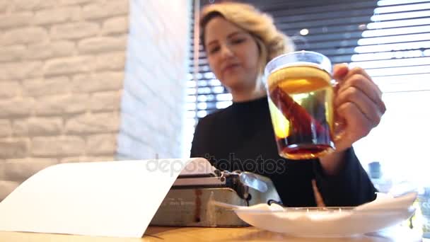 Writer in a cafe drinking cinnamon cider - Materiaali, video