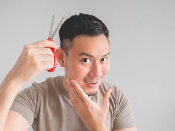 Asian man cut his own hair with clipper and scissor. - Foto, imagen
