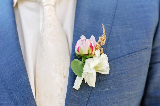 Pink peon boutonniere pinned to a grooms jacket - Photo, Image