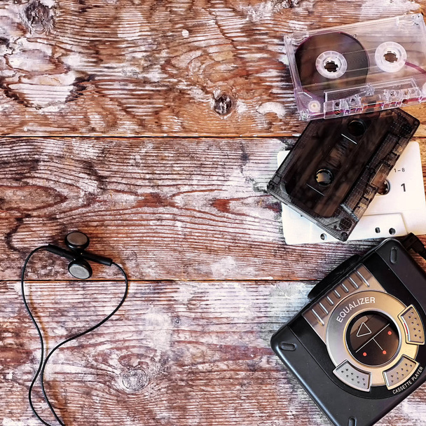 old cassette player and audio tape on a wooden background - Fotó, kép