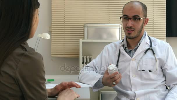 Male medical worker describing and giving pills to worried woman patient - Metraje, vídeo