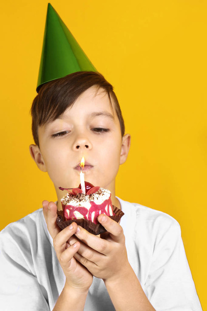Cute boy  with birthday mini cake on yellow background - Φωτογραφία, εικόνα