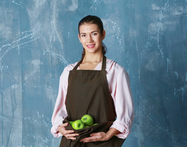 Woman holding apples in apron   - Фото, изображение