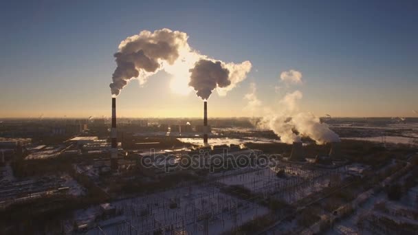 Savupiippujen voimalaitos auringonlaskun taustalla talvella. Antenninäköala
 - Materiaali, video