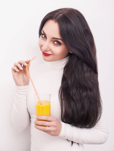Happy smiling young woman drinking orange juice - 写真・画像