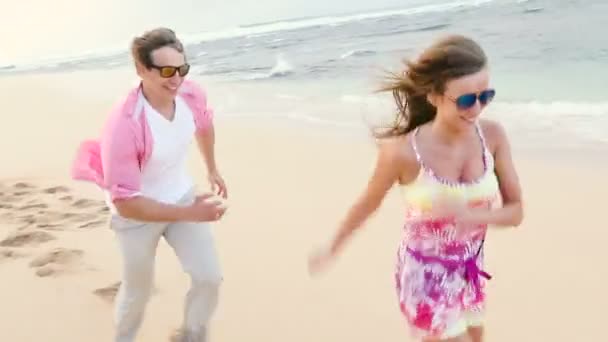 Atraente casal saudável se divertindo juntos correndo na praia
 - Filmagem, Vídeo