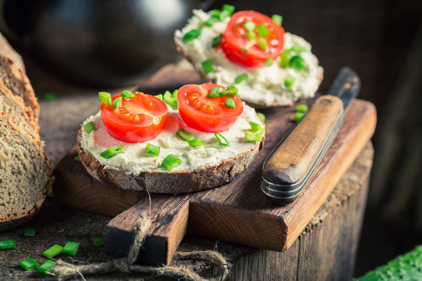Tasty sandwich with fromage cheese, cherry tomatoes and chive - Foto, afbeelding