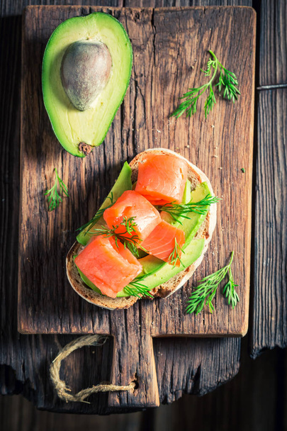 Tasty sandwich with avocado, dill and salmon - Foto, afbeelding