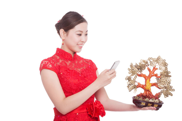 γυναίκα κατέχει κινητό τηλέφωνο και τυχερός δέντρο κινεζικό νέο έτος - Φωτογραφία, εικόνα