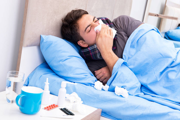 Больной человек с гриппом лежит в постели - Фото, изображение
