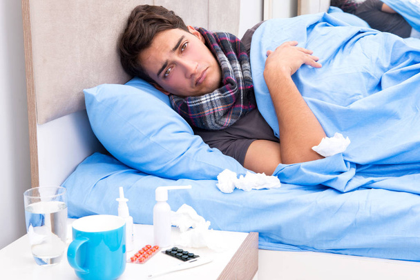 Sick man with flu lying in the bed - Фото, зображення