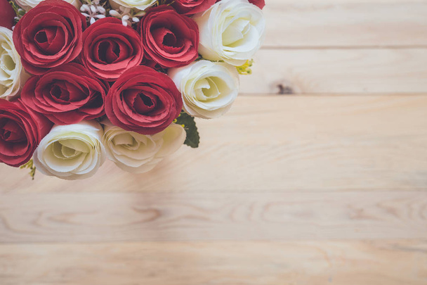 Bouquet of artificial rose flower on wooden plank. Top view - Fotografie, Obrázek