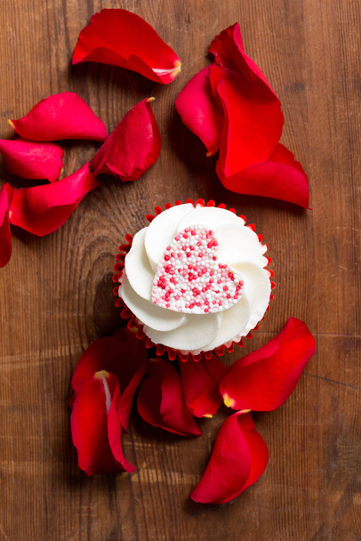 Cupcake del Día de San Valentín y pétalos de rosa
 - Foto, Imagen