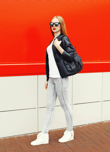 Fashion woman wearing a rock black jacket, sunglasses and bag wa - 写真・画像