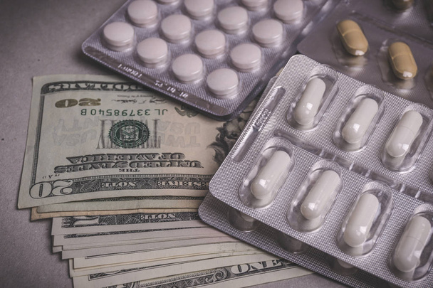 Geld für Gesundheit, Medikamententabletten, Tabletten und Kapseln auf dem Tisch. Drogen - Foto, Bild
