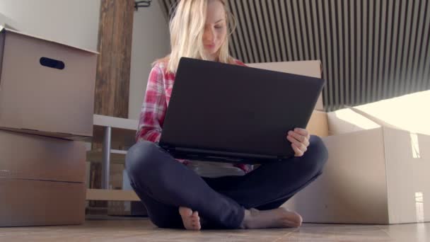 Dolly shot of happy young woman moving to a new house and using digital tablet. - Filmagem, Vídeo