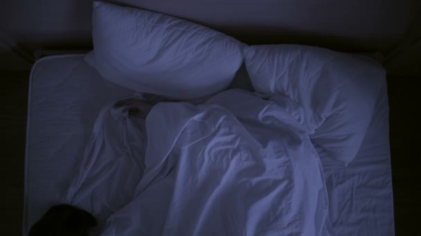 Insomnia concept. man in bed at night can not sleep - Felvétel, videó