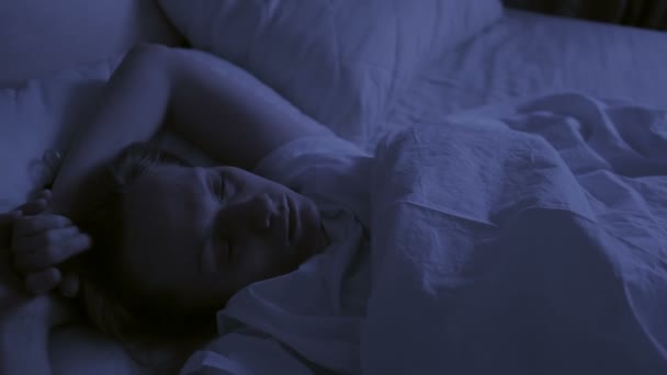 Insomnia concept. Woman in bed at night can not sleep - Materiał filmowy, wideo