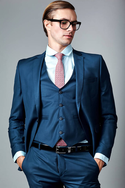  handsome businessman male model in blue suit  posing in studio - Zdjęcie, obraz