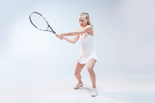 νεαρή γυναίκα που παίζει τένις - Φωτογραφία, εικόνα