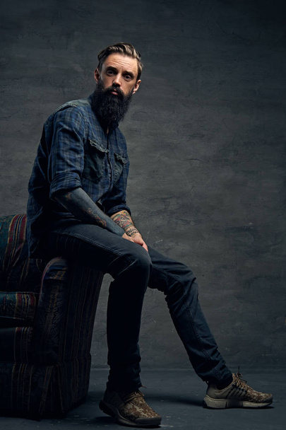 Bearded male sits on a chair - Photo, Image