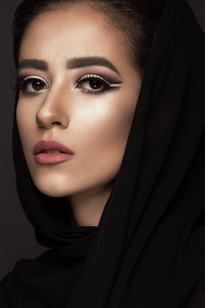 Beautiful girl in the Arab scarf with oriental make-up. Beauty face. - Fotó, kép