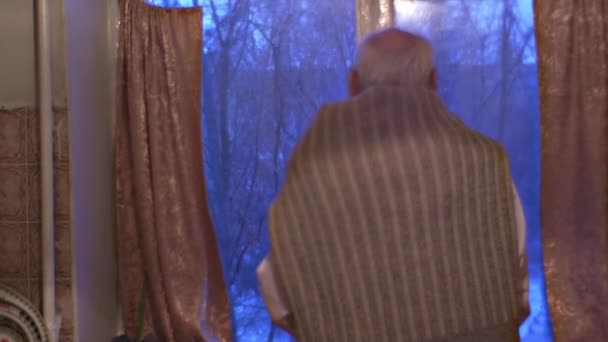Velho olhando através da janela esperando impacientemente por seus visitantes homem foi vestido em ocasião camisa branca em casa feliz em cumprimentar seus convidados
 - Filmagem, Vídeo