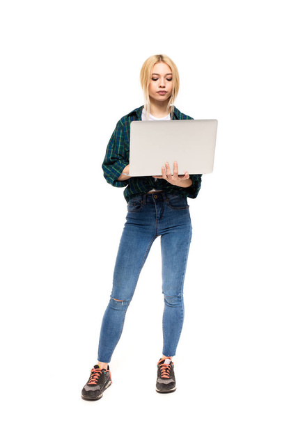 young blonde woman holding a laptop in hands - Fotó, kép