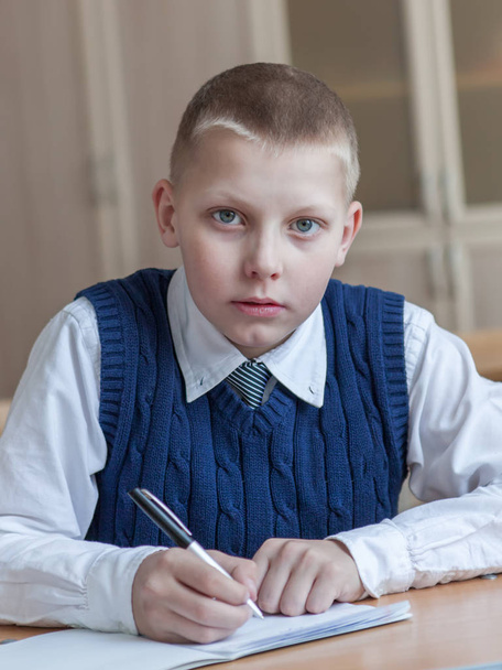 Diligent student sitting at desk, classroom - Фото, изображение