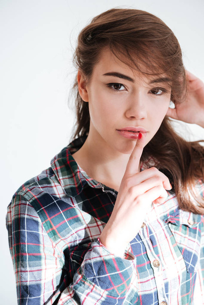 Attractive young woman in plaid shirt showing silence sign - Foto, Bild