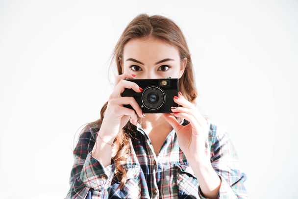 Woman holding camera over white background - Foto, imagen