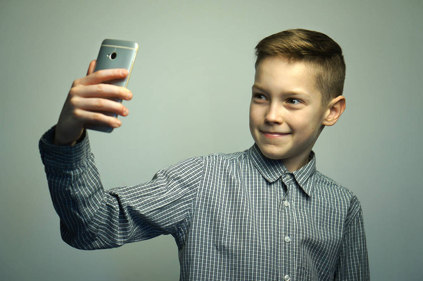 スマート フォンで selfie を取ってスタイリッシュな散髪と深刻な 10 代の少年 - 写真・画像