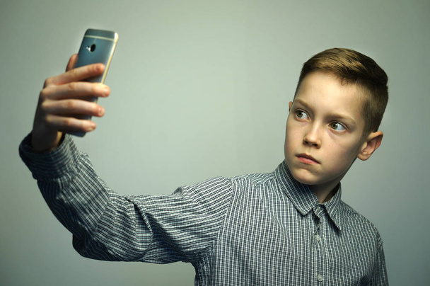 Teenage serious boy with stylish haircut taking selfie on smartphone - Foto, Imagen