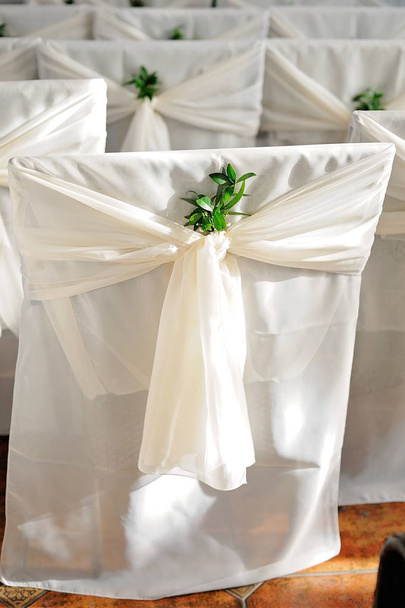 Řadách bílé svatební židle zdobené zelení - Fotografie, Obrázek