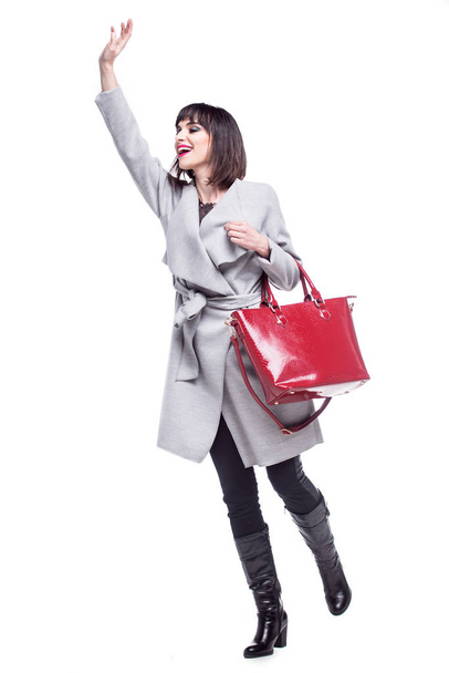 Beautiful woman dressed in a gray coat waving  - Fotografie, Obrázek