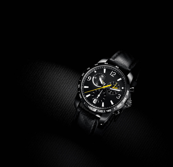 Nahaufnahme der Armbanduhr des netten Mannes auf schwarzem Hintergrund - Foto, Bild