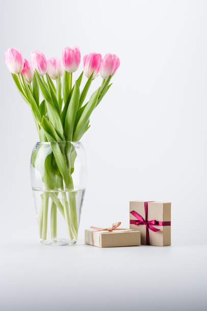 vaaleanpunainen tulppaanit ja lahjat
 - Valokuva, kuva